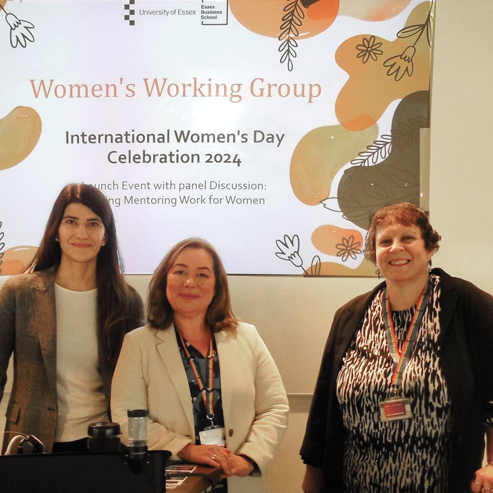 Dr Anna Sarkisyan, Dr Christina Ferreira and Teresa Alvarez stand in front of a screen which says Women's Working Group