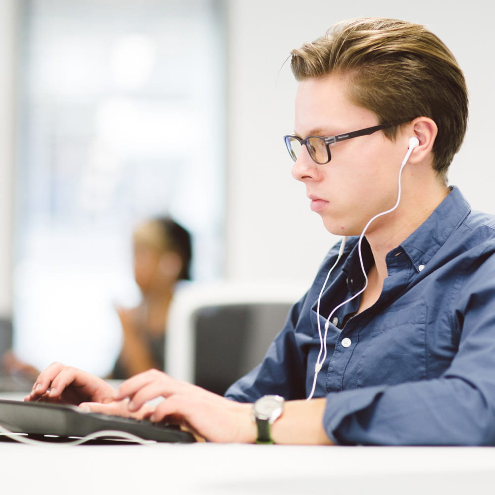 年轻人戴着耳机使用电脑