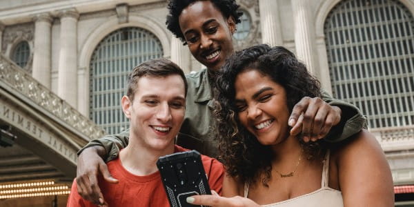 3 students looking at a phone