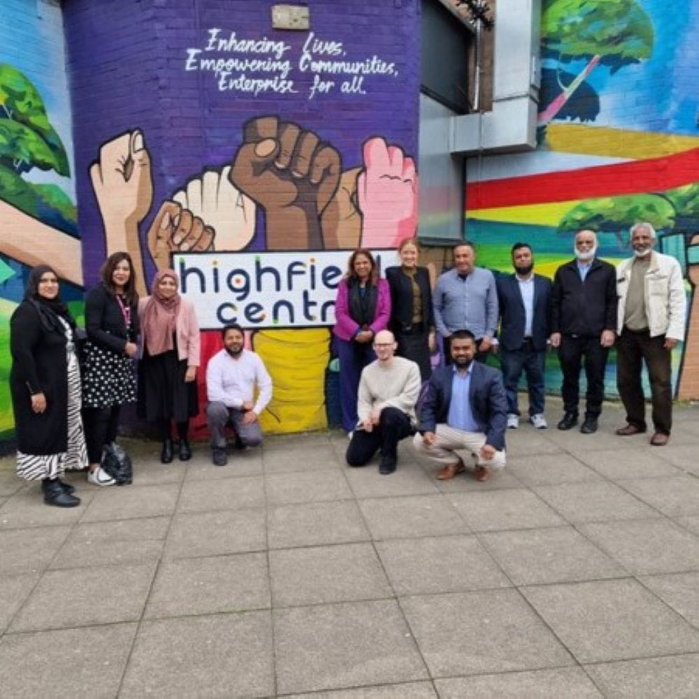 An image of the members of the THRREADS team standing next to a colourful mural