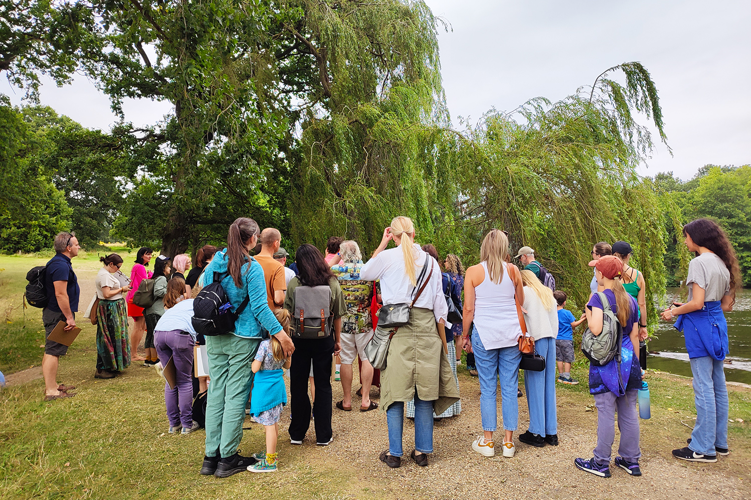 a group of people gather around the trees in wivenhoe park while on a foraging workshop with Lora Aziz