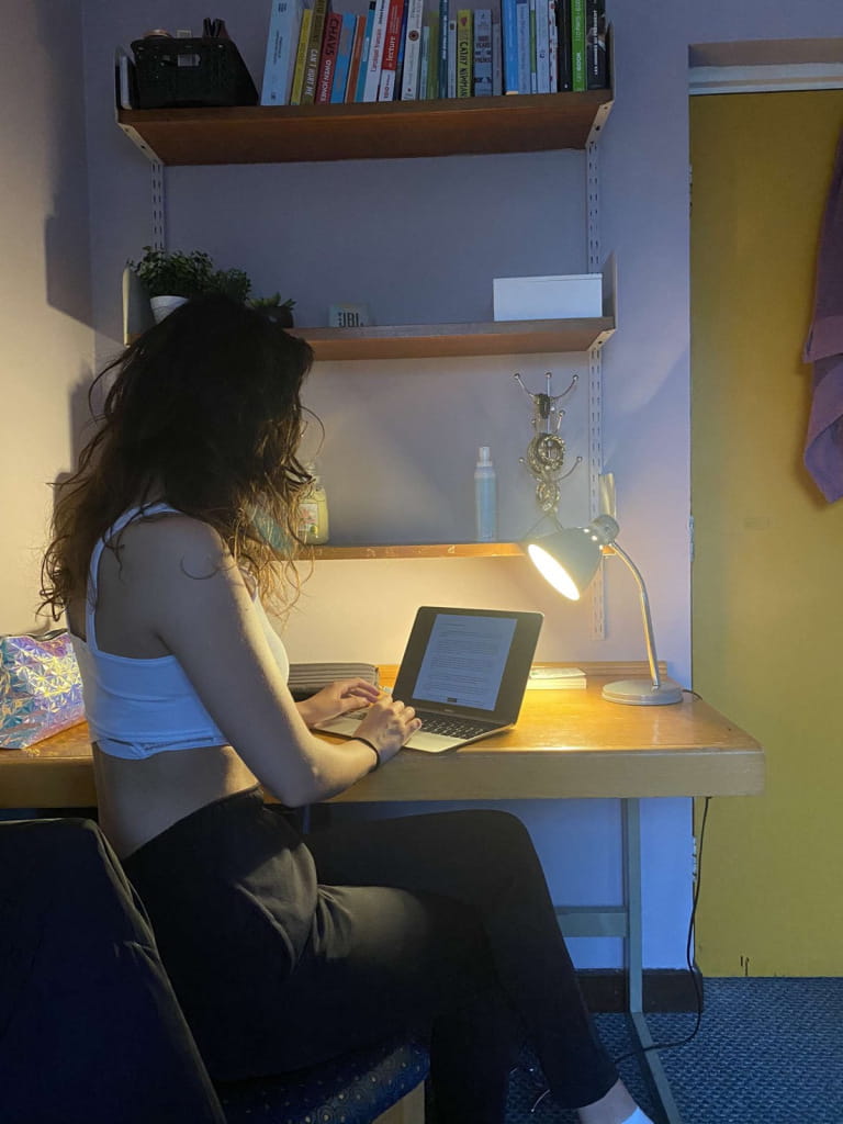 Margaux working at a laptop in her room