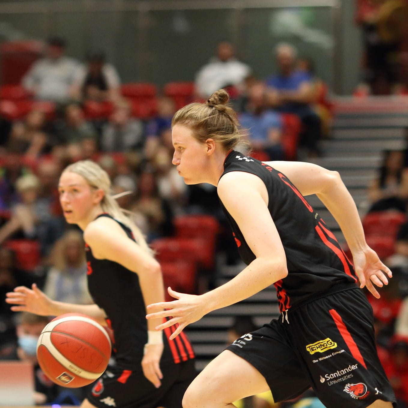 Two people playing basketball