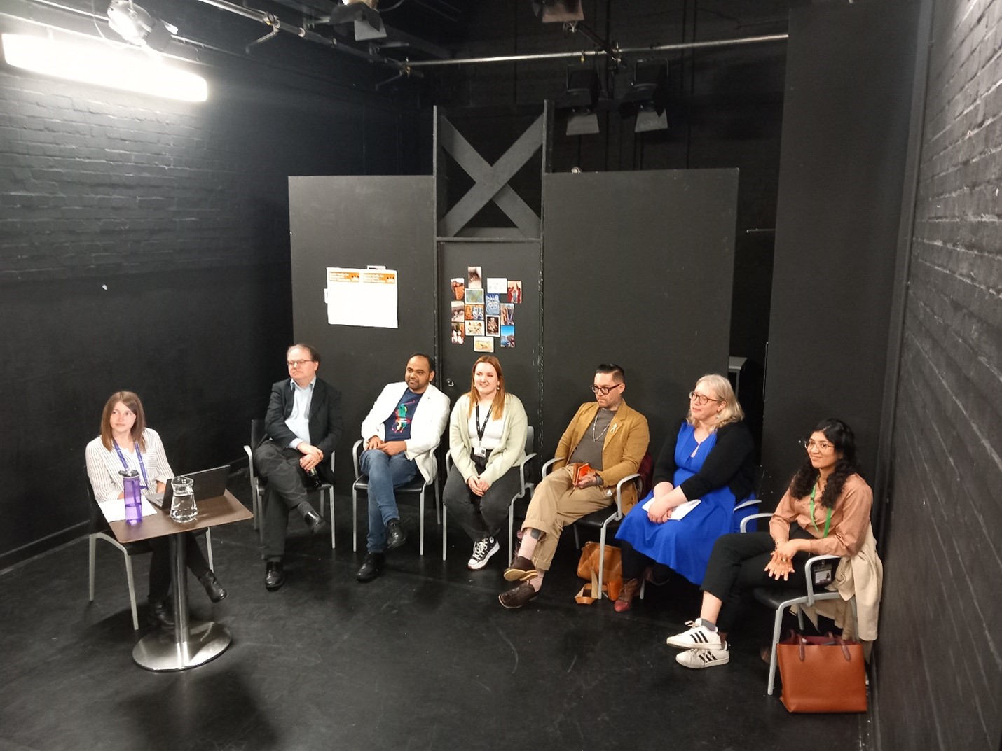 The six panellists, and the host , all seated and looking up to the audience.