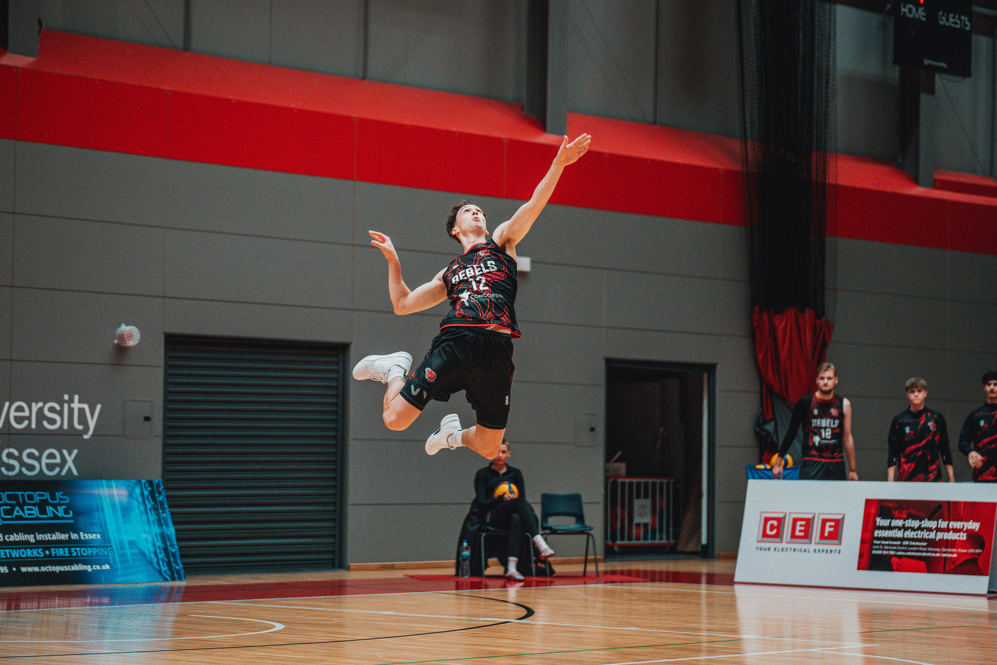 Volleyball player jumping in the air in sports arena