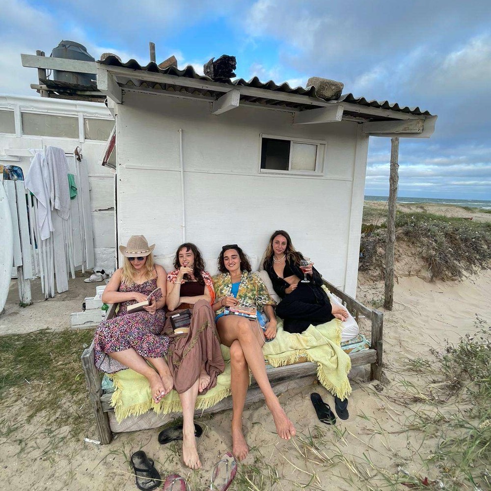 A group of friends sat in front of a beach hut
