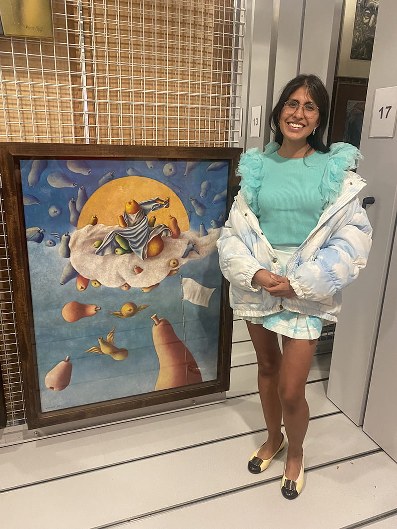 Assistant Curator of ESCALA and the University Art Collection, Gisselle Giron wears 1990s Moschino Jeans jacket and skirt and stands next to Ramiro Arango’s “Assomption avec l’artiste” (1995) in the ESCALA Teaching and Research Space.