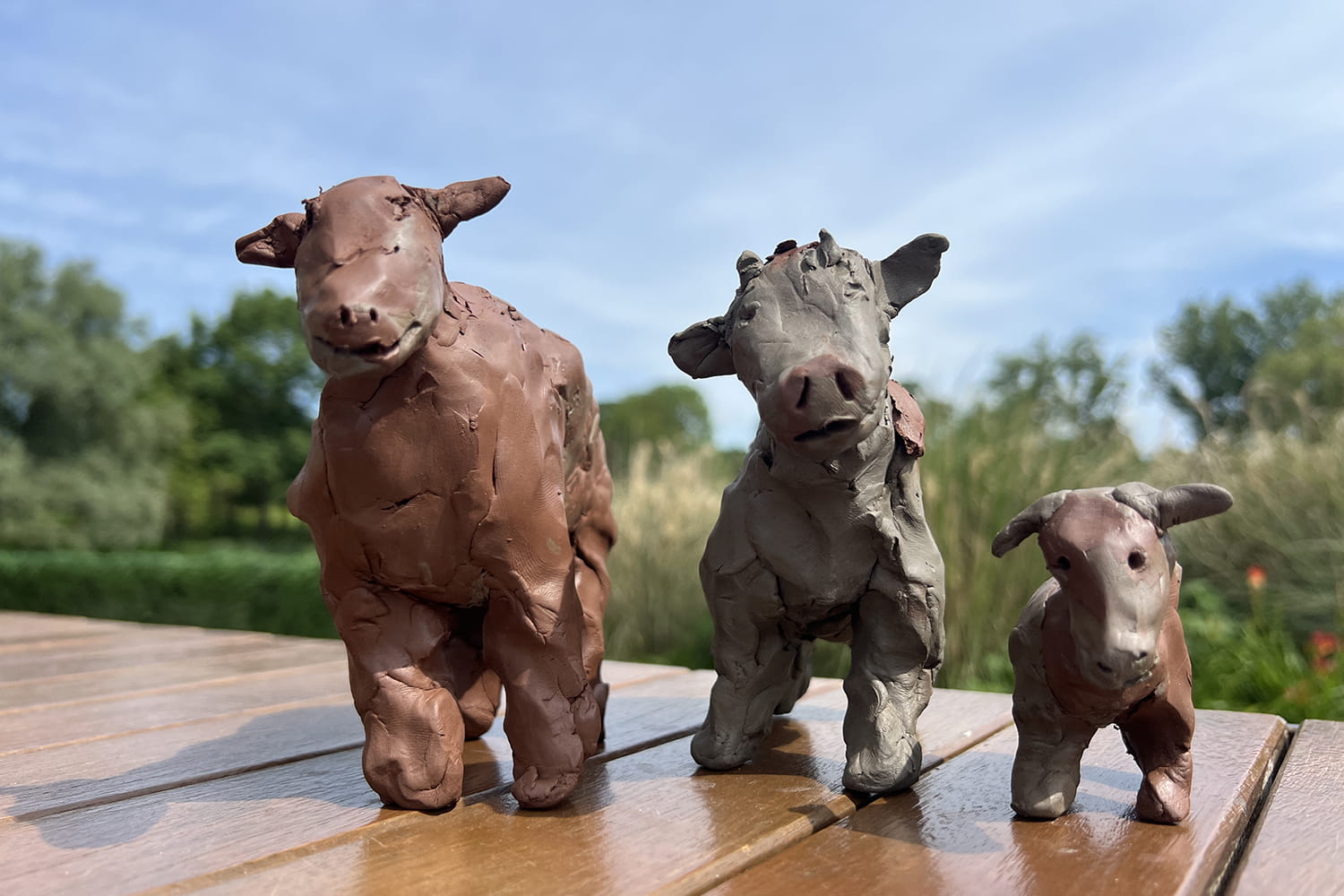 three clay cows stand on a table on the Sliberrad Plaza