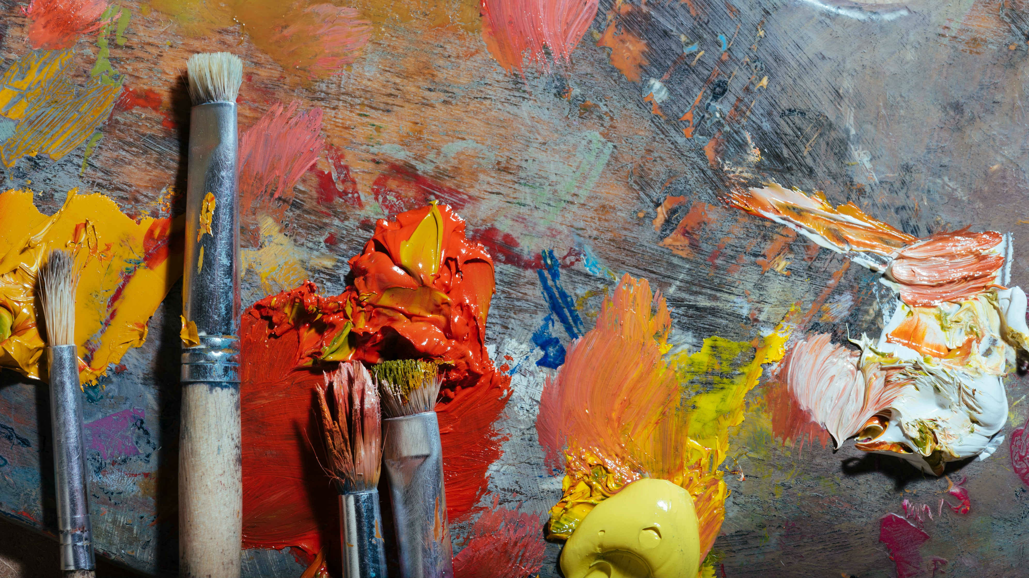 paint brushes and thick paint laid on a palette