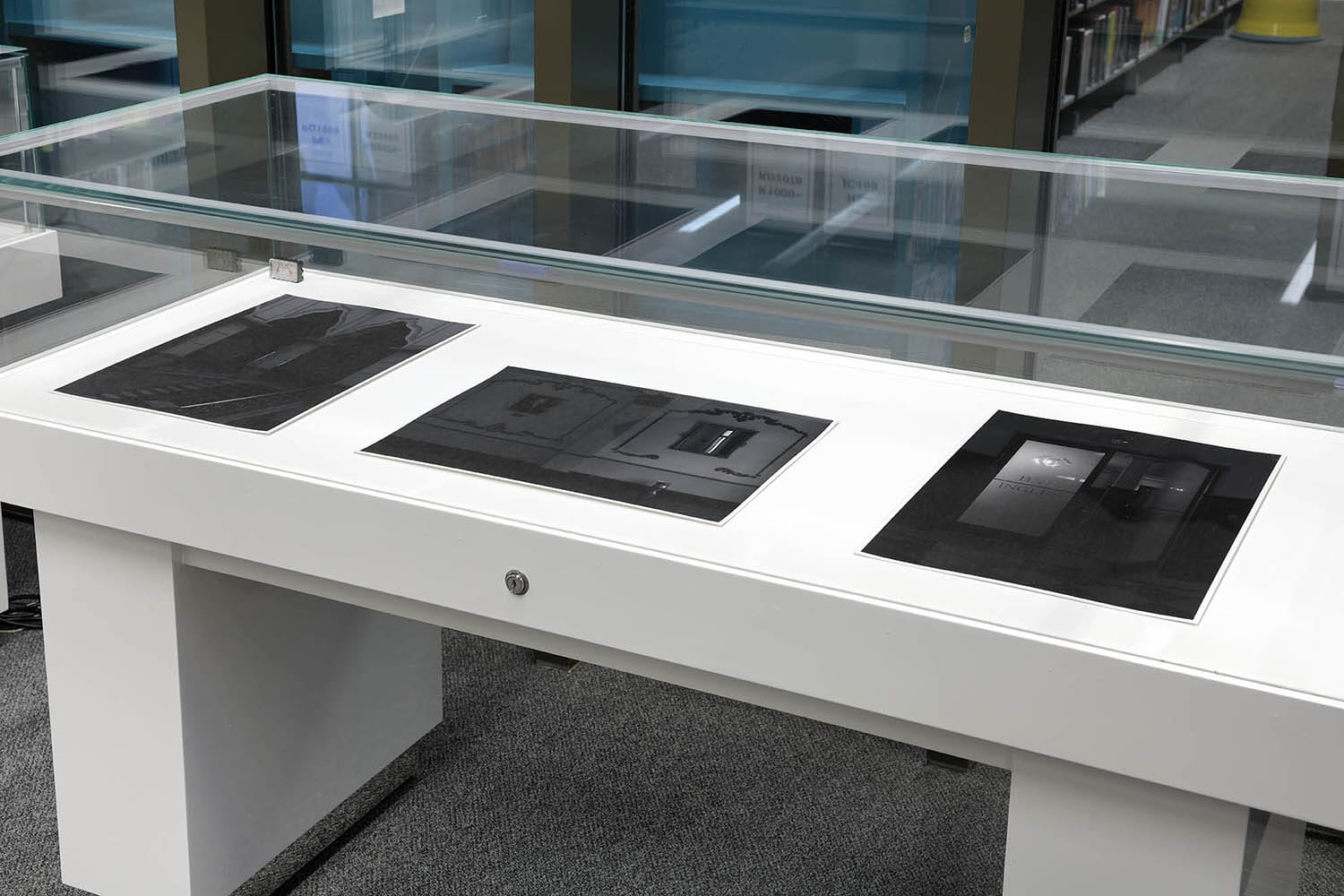 A cabinet in the Albert Sloman Library showcasing three of Lucero Del Castillo Ames The Union Club photographs