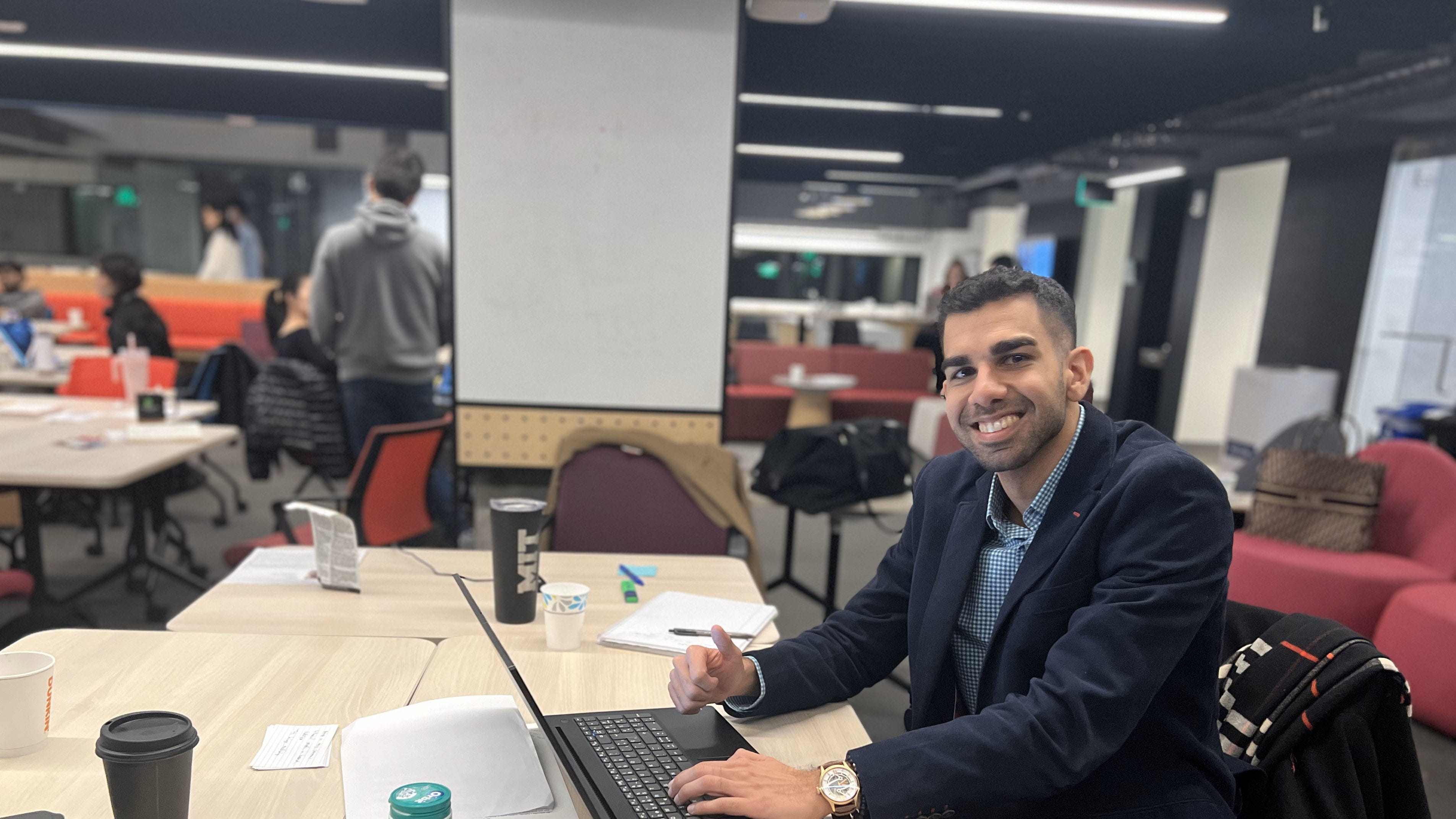 Mahesh sitting at a desk smiling at the camera