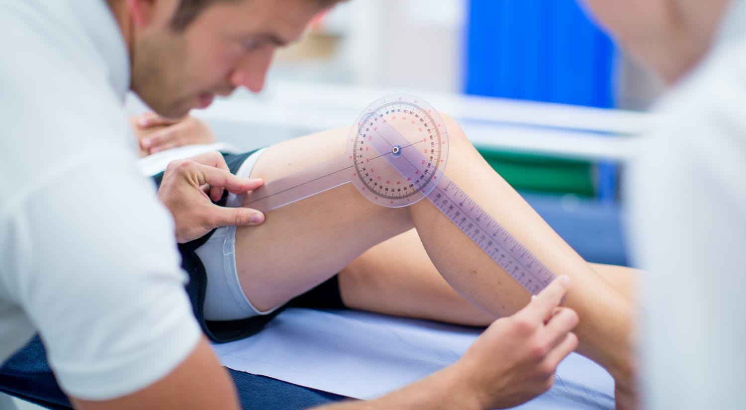 A Sports Therapy student measuring the angle of a patient's knee joint.