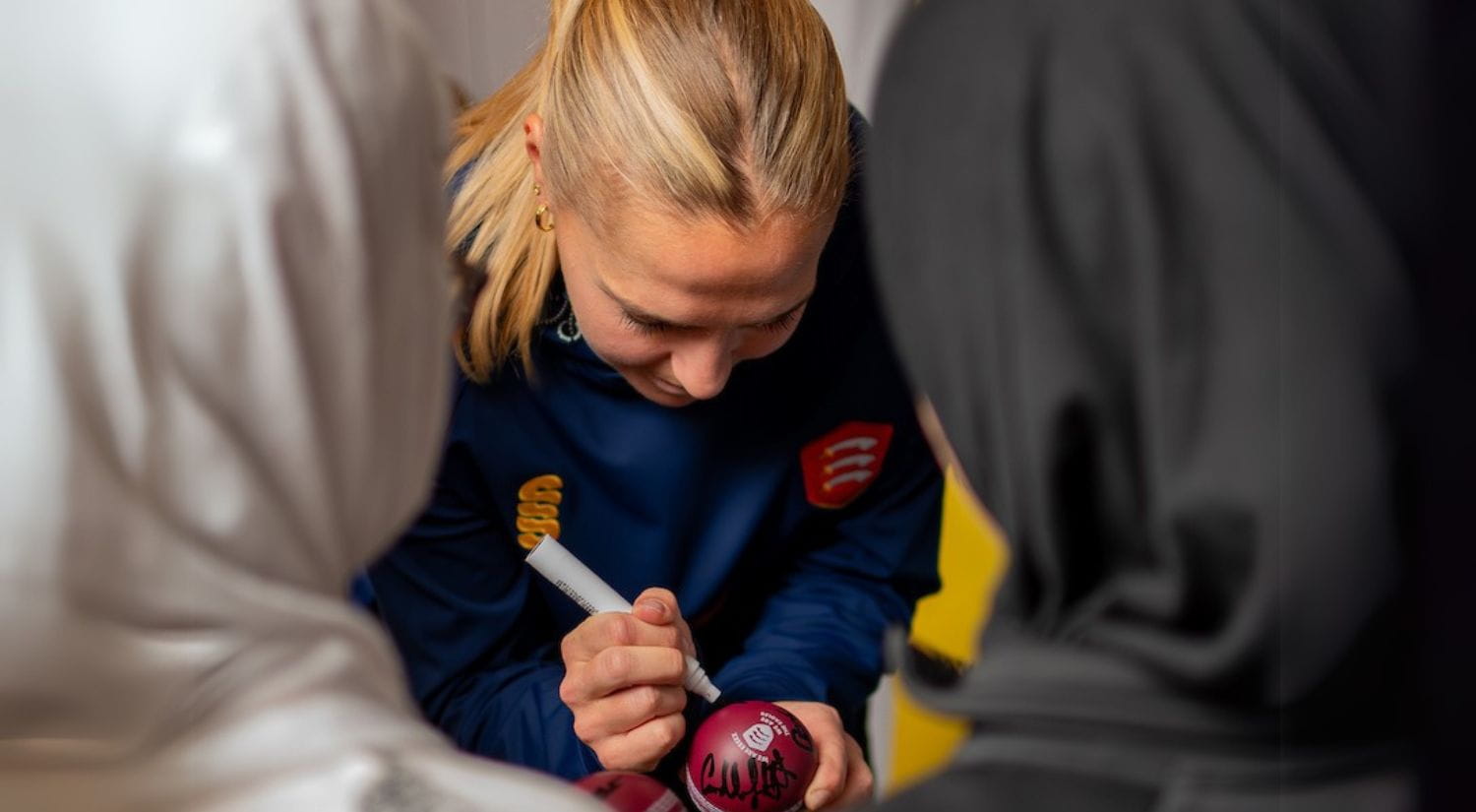 Young girls getting a ball signed