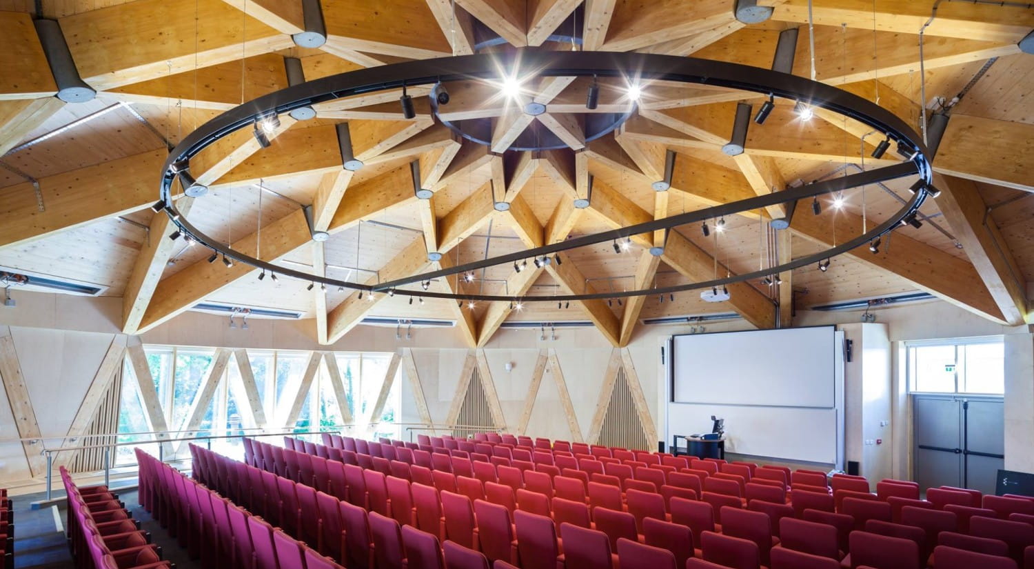 The lecture theatre at Essex Business School, with exposed wooden ceiling and red seats.