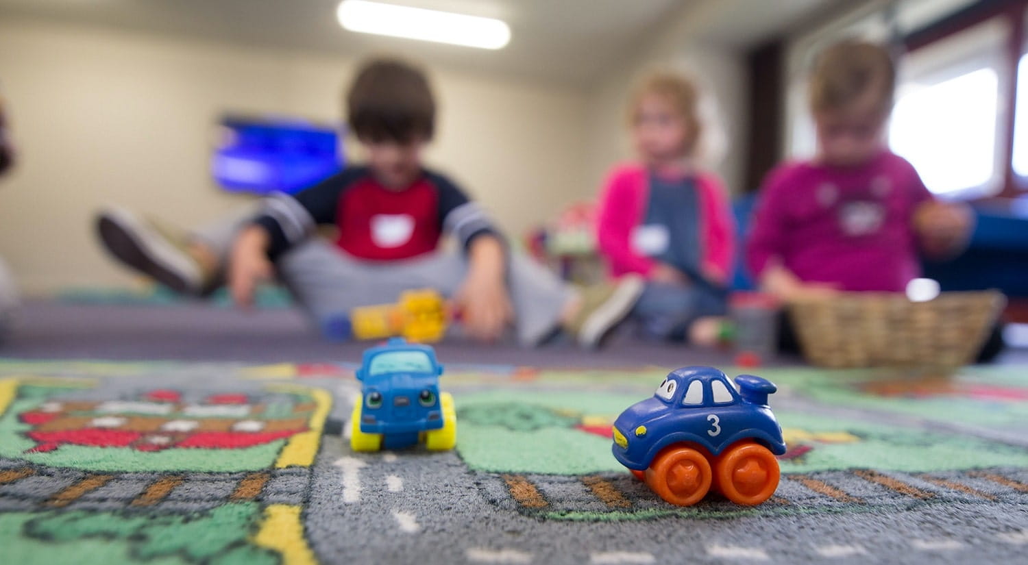Children in care playing with toys, a possible career as a care worker for students of Therapeutic Communications and Therapeutic Organisations.
