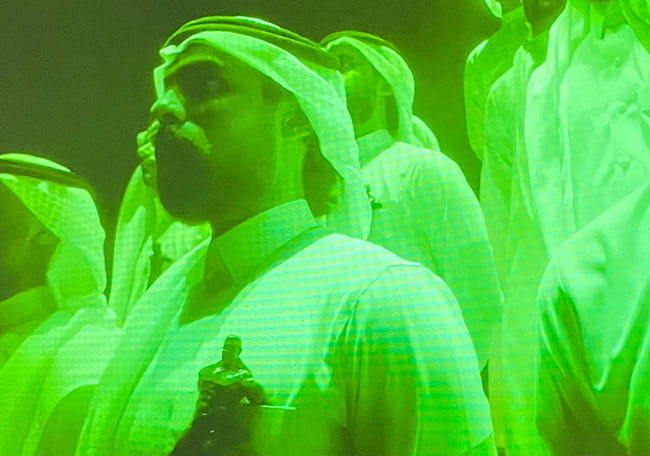A man stands, bathed in green light. From ‘The Green Light’ (2021) by Ahaad Alamoudi, New Contemporaries, Camden Art Centre, 2024