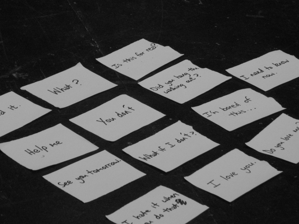 Pieces of paper laid out on a table, each with a statement or question on them as prompts. 