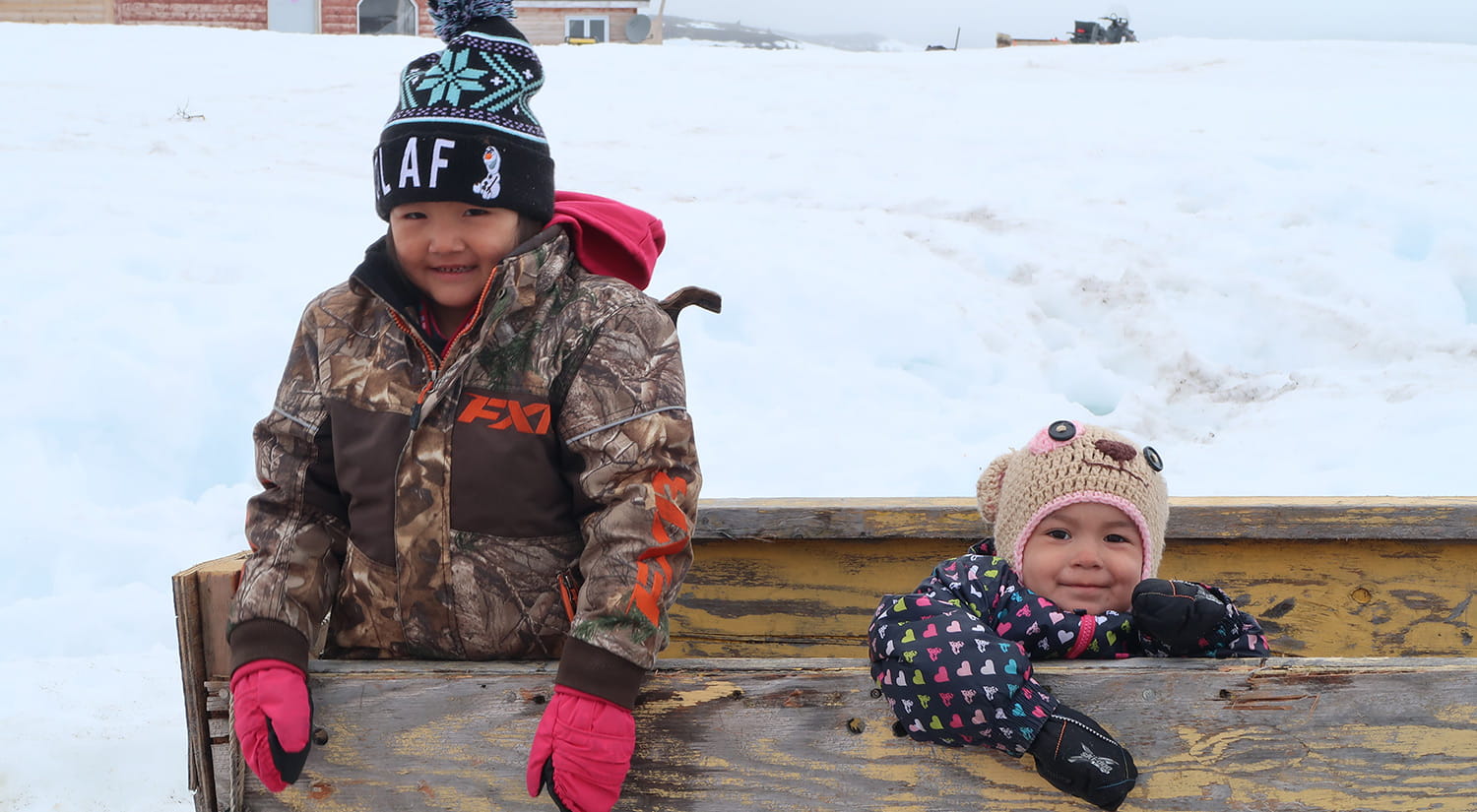 Shione and Theresa Mae Pijogge on komatik (toboggan) at Ashuapun, 2016