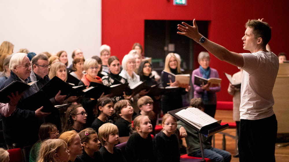 Ben Vonberg-Clark conducting both the adult and children's choir